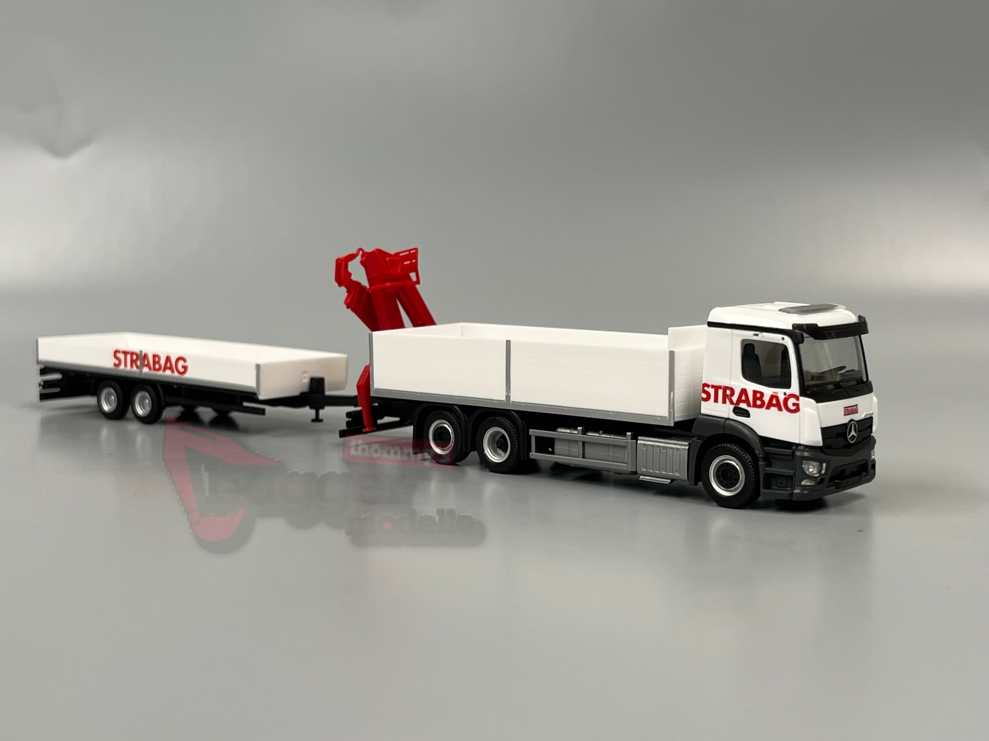 320665 - Herpa -Mercedes-Benz Actros M Baustoff-LKW mit Kran und Tieflade-Anhänger "STRABAG" (Österreich